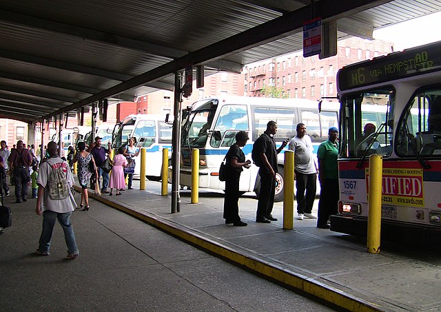 Passengers board buses at the terminal.