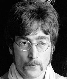 Lennon nel 1967 all'epoca di Sgt. Pepper's, con i celebri occhialini tondi e i baffi da tricheco