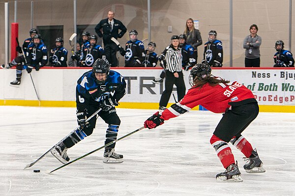 Whitecaps Kate Schipper (6) and Riveters Lexi Slattery (15) in the 2018–19 season opening weekend at Tria Rink.