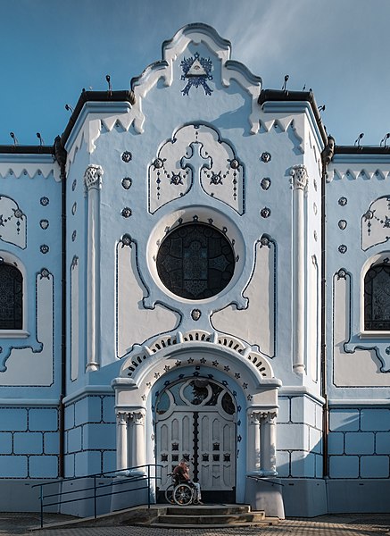 File:Man on a wheelchair prays in front of the North side entrance of the Church of St. Elisabeth (Blue Church) (Bratislava, Slovakia) julesvernex2.jpg