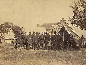Lincoln among a group of soldiers in a military camp
