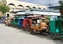 Motor tricycles for hire lined up outside public market in downtown Bantayan