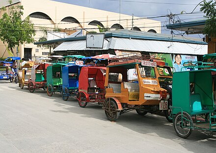 Motor tricycles for hire lined up outside public market in downtown Bantayan, Cebu
