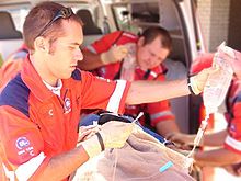 A paramedic preparing an intravenous infusion for a patient Patient Care.jpg
