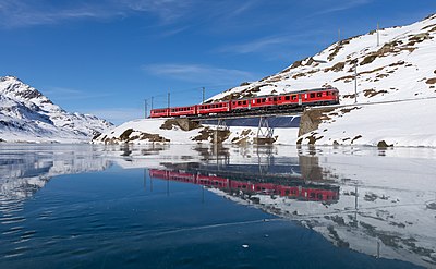 Die twee RhB-treine ABe 4/4 III 55 "Diavolezza" en 54 "Hakone" kruis die "Am See"-brug met die Regio 1625 na Tirano. Afgeneem naby Ospizio Bernina, Switserland.