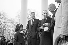 February 26, 1962: John Glenn receives key to the city in Washington, D.C., as six-year-old Maria Shriver looks on ST-82-1-62. Astronaut John Glenn Receives Key to City at White House Reception.jpg