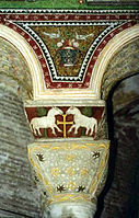 Decoración de mosaico y relieve policromado en los arcos y el capitel y cimacio de una columna en San Vital de Rávena, arte bizantino del siglo VI.
