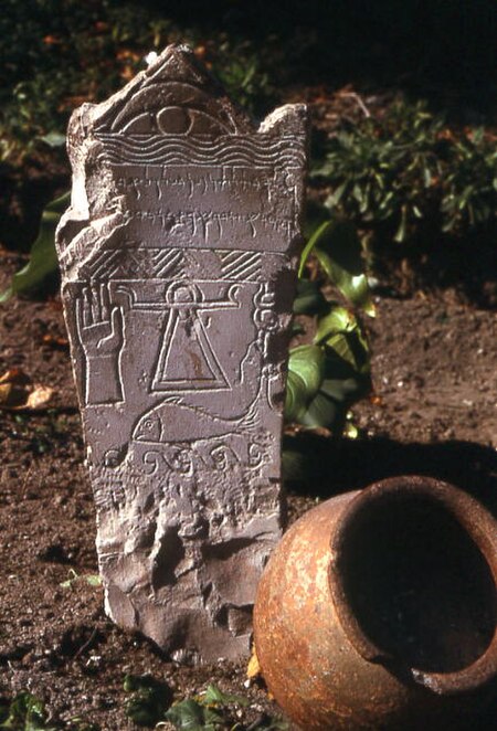 A Punic stela from Carthage dedicated to Tinnit and Baal Hammon with a carved open right hand, as well as sign of Tinnit, sign of Baal Hammon above, C