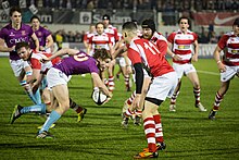 A UCL player attacks in his team's 2014 Varsity victory. UCL's traditional rivalry with King's College is nowadays most noticeable at the annual varsity rugby game. UCL-KCL Varsity Rugby 2014.jpg