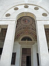 The serliana of the atrium, with the family's coat of arms and military trophies.