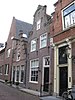 Huis met halsgevel, voorzien van beeldhouwwerk in lod