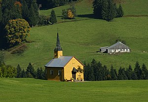 rechteckige Kapelle mit einem Schindelpanzer sowie einem Dachreiter mit hohem Pyramidenspitzhelm