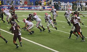 Georgia's offense executes a running play as Virginia Tech defenders run to stop the advance. 2006 VT UGA Chick fil A action.jpg