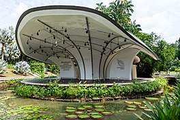 Symphony Lake covered in lotus plants floating in the lake with the Shaw Foundation Symphony Stage in the middle.