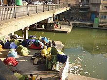 A group of young men camping by the Canal Saint-Martin in Paris, France, in 2010. According to the photographer the campers are Afghan refugees. Afghan refugees, living on the Canal Saint Martin, underneath a bridge.jpg