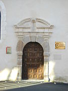 Fotografia de uma porta de madeira semicircular.