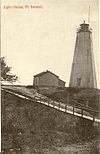 Black and white postcard of the wooden lighthouse at the top of the harbour at Port Burwell, ON. The road runs down to the bridge over Otter Creek.jpg