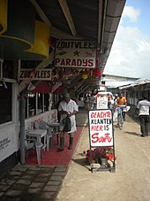 Butcher in the Central Market in Paramaribo with signs written in Dutch Butcher Paramaribo market.jpg