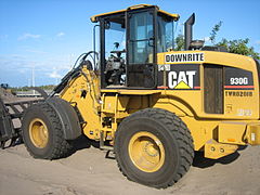 A Caterpillar 930G fitted with a loader rake on a residential construction site in South Florida.
