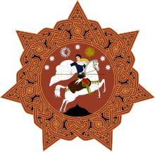 A round orange badge with six points and a horse-mounted man in the centre