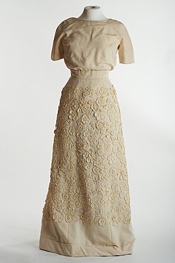 Cream evening gown from 1964 featuring crochet details.