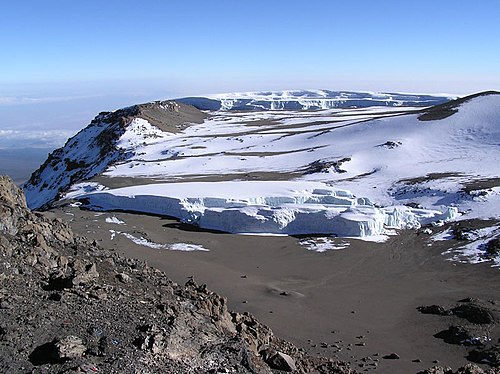Furtwängler Glacier atop Kilimanjaro in the foreground and snowfields and the Northern Icefields beyond.