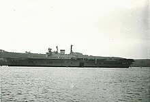 The Royal Navy aircraft carrier HMS Eagle moored in the Hamoaze. In 1972, the ship was decommissioned from active service but retained to serve as a source of spares for HMS Ark Royal. HMS Eagle (11114636924).jpg