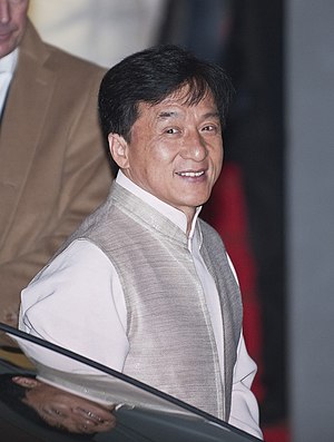 Actor Jackie Chan staring to the left of the camera with a smile.