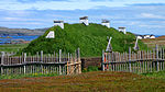 Grass-covered house with wooden chimneys.