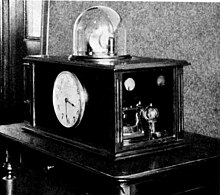 One of the first experimental quartz controlled clocks, built by Warren Marrison at Bell Labs in 1927. A vacuum tube oscillator controlled by the 100 kHz quartz crystal (under dome at top) is divided down by vacuum tube counters and runs the synchronous clock on front. Accuracy was 0.01 second per day Marrisons quartz crystal clock.jpg