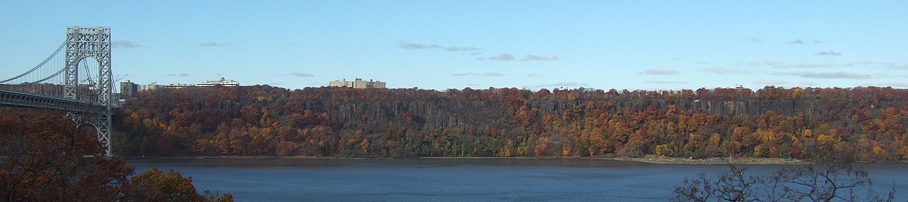 The Palisades, with fall foliage. On the left is the George Washington Bridge. A controversial plan to build a high-rise that would have broken the tree line was proposed, and later modified, by LG Electronics.[22]