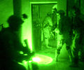 Seen through a night-vision device, paratroopers conduct a raid on a suspected terrorist's home in Fallujah, Iraq.