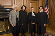 The justices standing side-by-side, smiling