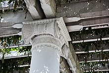 Detail of the trellis above the dais, showing the cast iron Ionic capitals, double-girder bolted beams, and cross-braces. Old Amphitheater - colonnade capital detail - Arlington National Cemetery - 2011.JPG