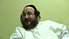 A Jewish man wears a black Kippah