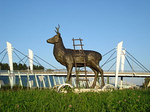 Sculptuur hert-op-wielen en spoorviaduct