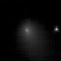 This image shows comet Tempel 1 as seen by the Deep Impact spacecraft on June 19, 2005. It was taken using the clear filter of the spacecraft's medium resolution imager camera. The spacecraft was 13,341,692.5 kilometers (8,290,528 miles) away from the comet. Four images were combined together to create this picture, and a logarithmic stretch was applied to enhance the coma of the comet. The star to the right is six times brighter than the brightest pixel of the comet.