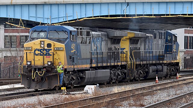 A conductor rides on a pair of CSX AC4400CW locomotives in Worcester, MA.