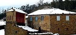 Town view with an hórreo and a house.