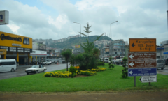 Photographie d'une zone urbaine.  Il y a des rues, des panneaux de signalisation et des espaces verts.