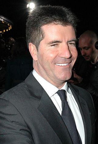 A picture of a man with black hair wearing a grey suit