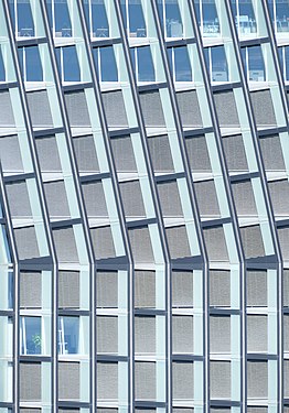 close up of windows in a modern office towers, in the lower part of the pictures the window frames are straight, in the upper part they are slanted
