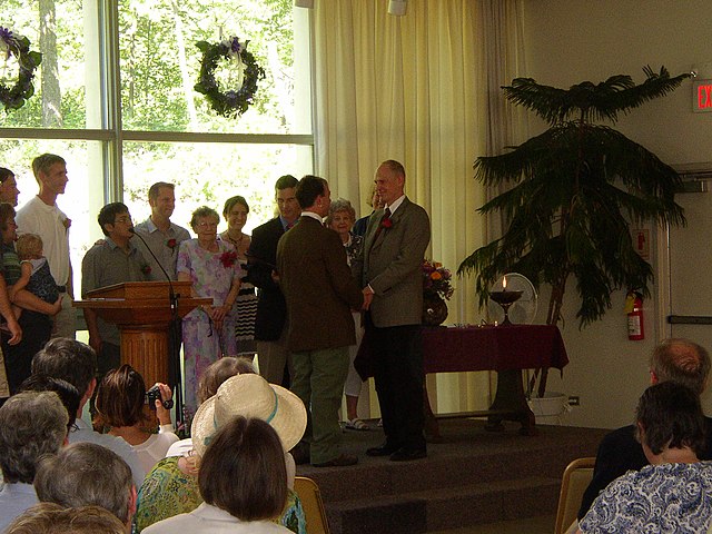 A same-sex couple exchanging wedding vows in a Unitarian Universalist Fellowship