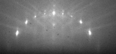 Figure 2. A RHEED pattern obtained from electron diffraction from a clean TiO2 (110) surface. The bright spots indicate where many electrons reach the detector. The lines that can be observed are Kikuchi Lines. TiO2 Good Surface.gif