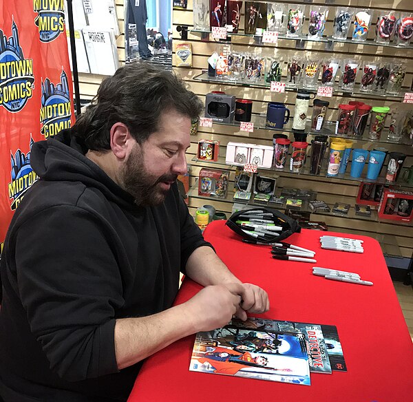 Tomasi autographing an issue of Super Sons during a 2019 signing at Midtown Comics in Manhattan