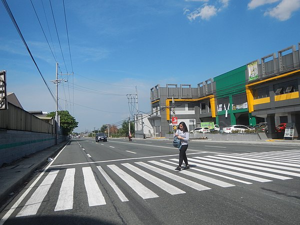 A woman at a marked crossing in Carmona, Philippines