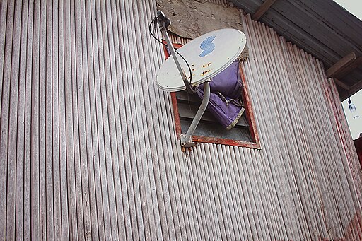 A bamboo house fitted with a TV satellite dish