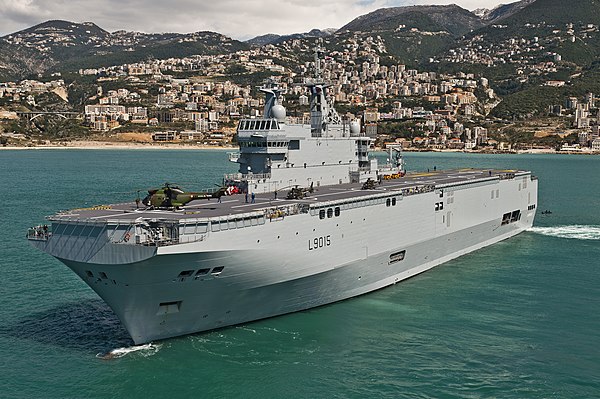 The French Navy Mistral-class amphibious assault ship Dixmude manoeuvering in Jounieh bay; the wake at the stern is perpendicular to the ship, indicat