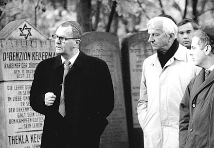 (l-r) President of the East Berlin Jewish Community Peter Kirchner [de], President of the Federal Republic of Germany Richard von Weizsäcker, and Barenboim visit Jewish cemetery in Berlin-Weissensee (1990)