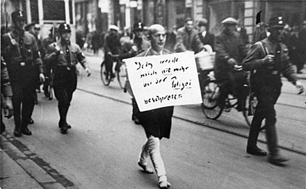 Taken in March 1933, immediately after the Nazis seized power, this photo shows Nazi SA militants forcing a Jewish lawyer to walk barefoot through the streets of Munich wearing a sign that says "I will never again complain to the police"